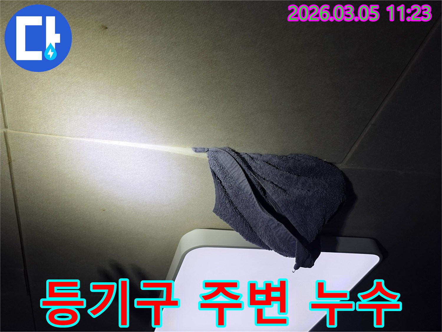 천장에서-물이-새어-나와-수건으로-받고-있는-긴급-누수-상황을-보여주는-이미지