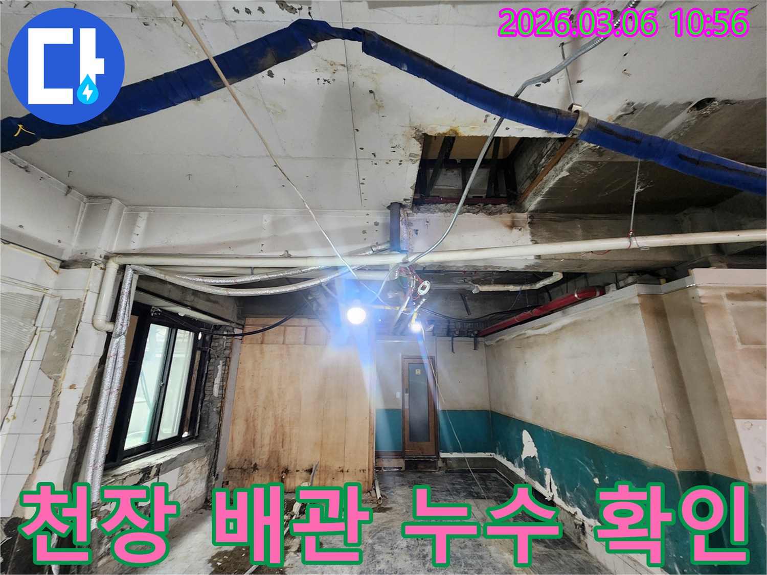 천장 내부의 배관에서-누수가 발생한 지점을-전문가가 확인하는 모습