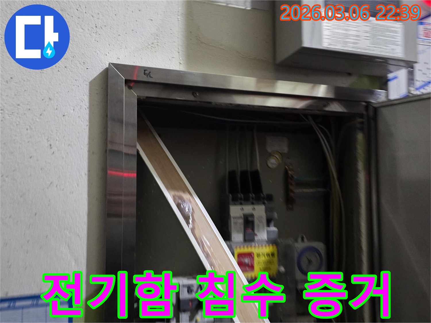 누수로 인해 전기 패널의 일부가-젖어있는 상태를-명확하게 보여주며-즉각적인 조치의 필요성을-알려줍니다.