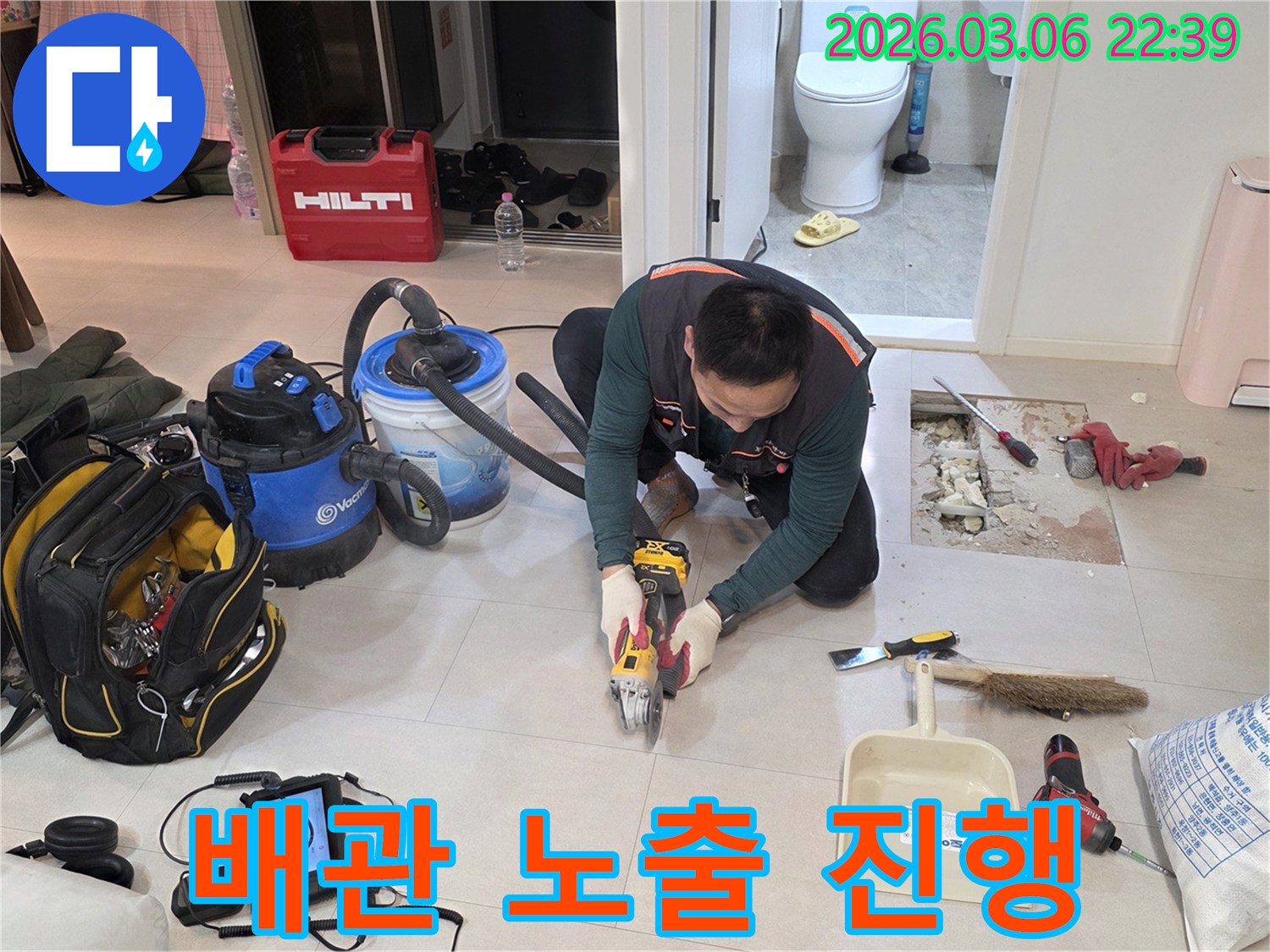 숙련된-기술자가-누수-수리를-위해-바닥-타일을-조심스럽게-절단하여-배관을-노출하는-모습입니다.