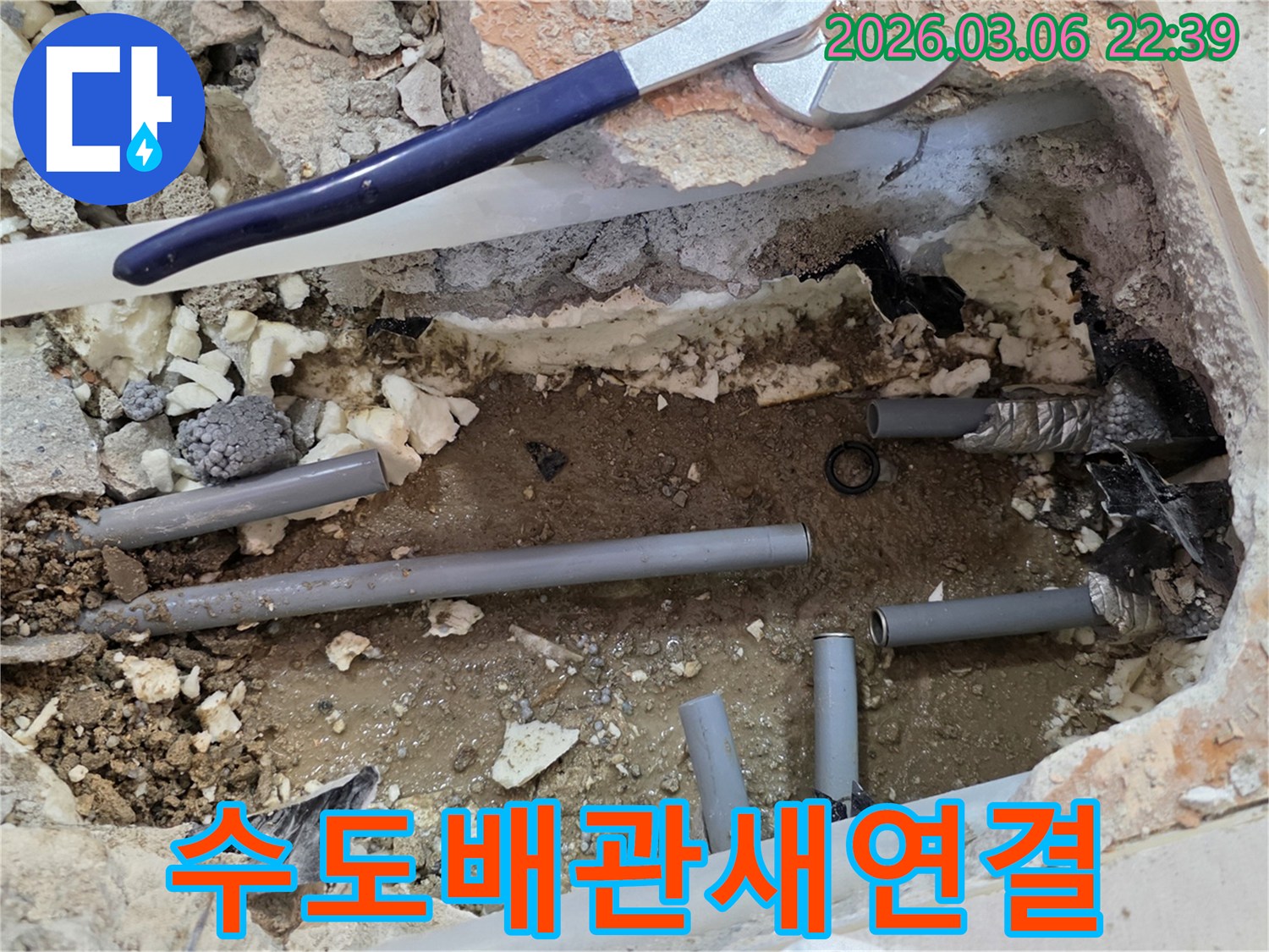 이 사진은 수도 배관에서 발생한 누수를 해결하기 위해-바닥을 개방하고 손상된 배관을 새로운 것으로 교체하여 연결하는 현장을 보여줍니다