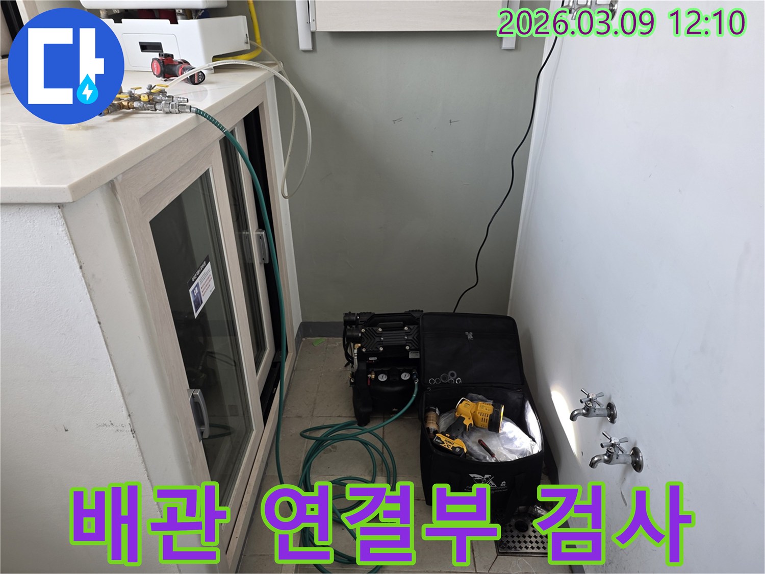 배관 연결부의 누수 여부를 정밀하게 검사하기 위해 압력 장비를 설치하는 과정입니다.