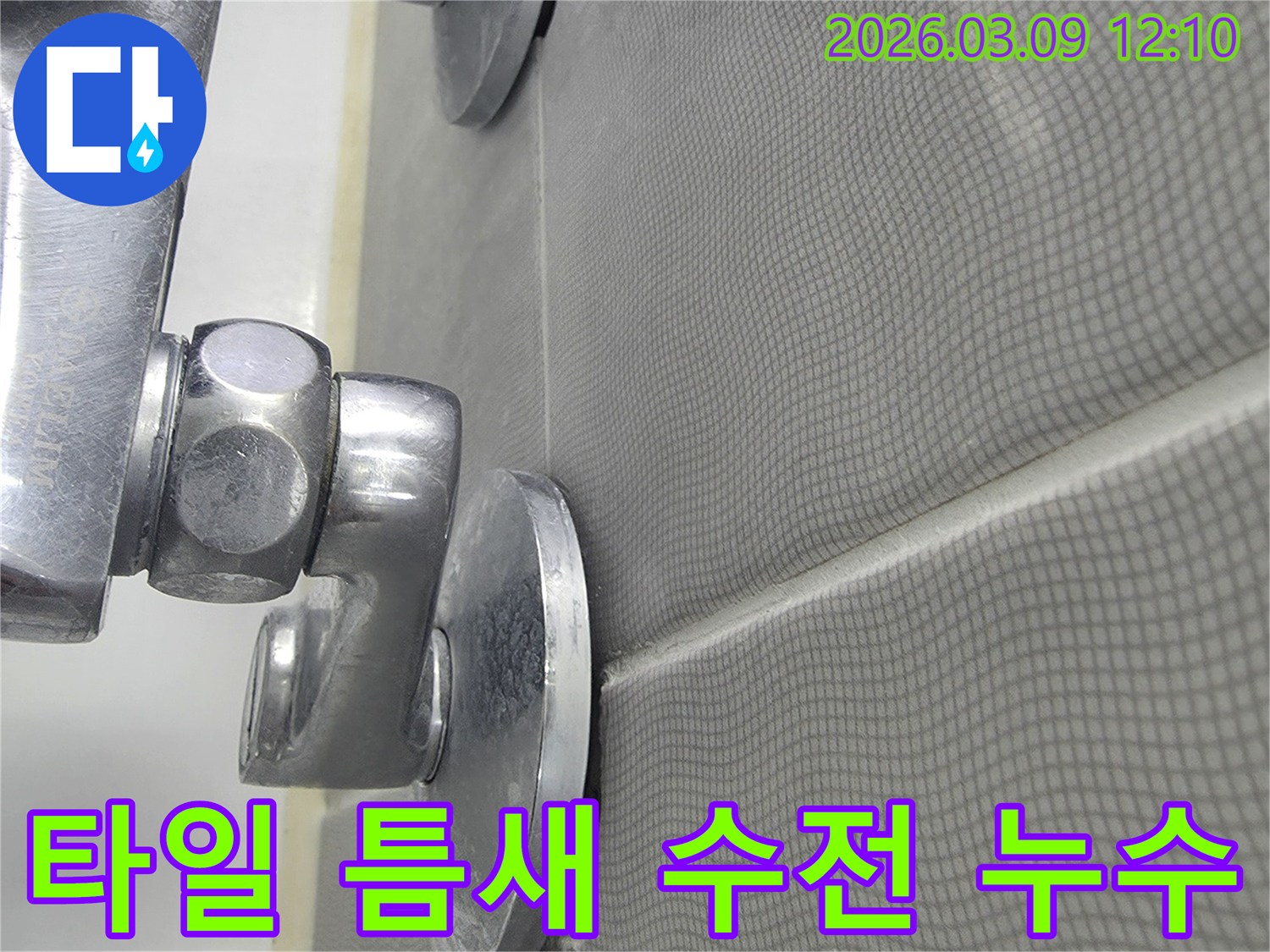 욕실 샤워기 수전 주변의-타일 틈새에서-누수 흔적을 확인하고-보수 공사를 준비하는 모습