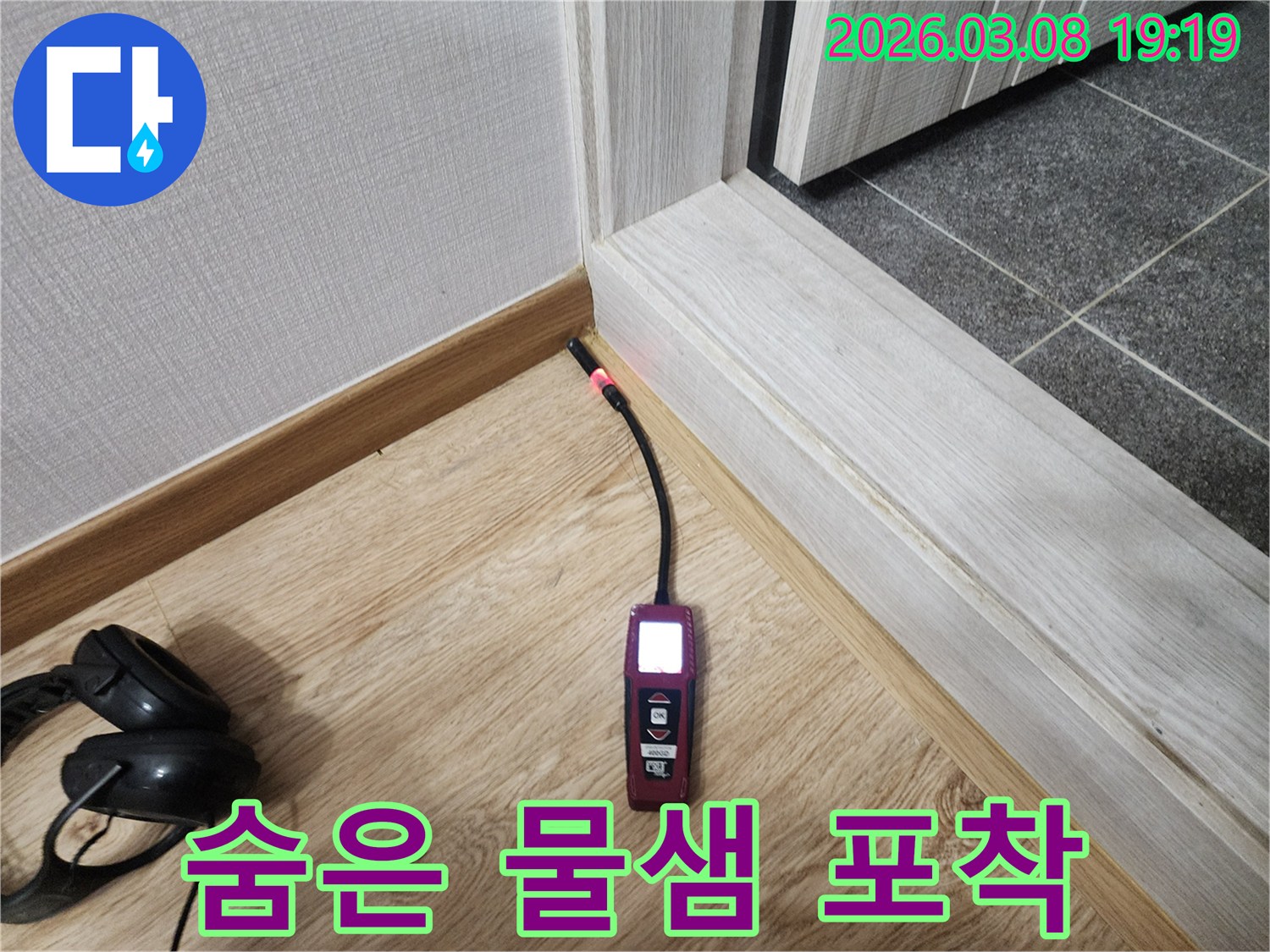 나무-바닥과-벽-모서리에서-누수탐지기가-붉은색-표시등으로-숨겨진-누수-지점을-정확히-가리키는-모습