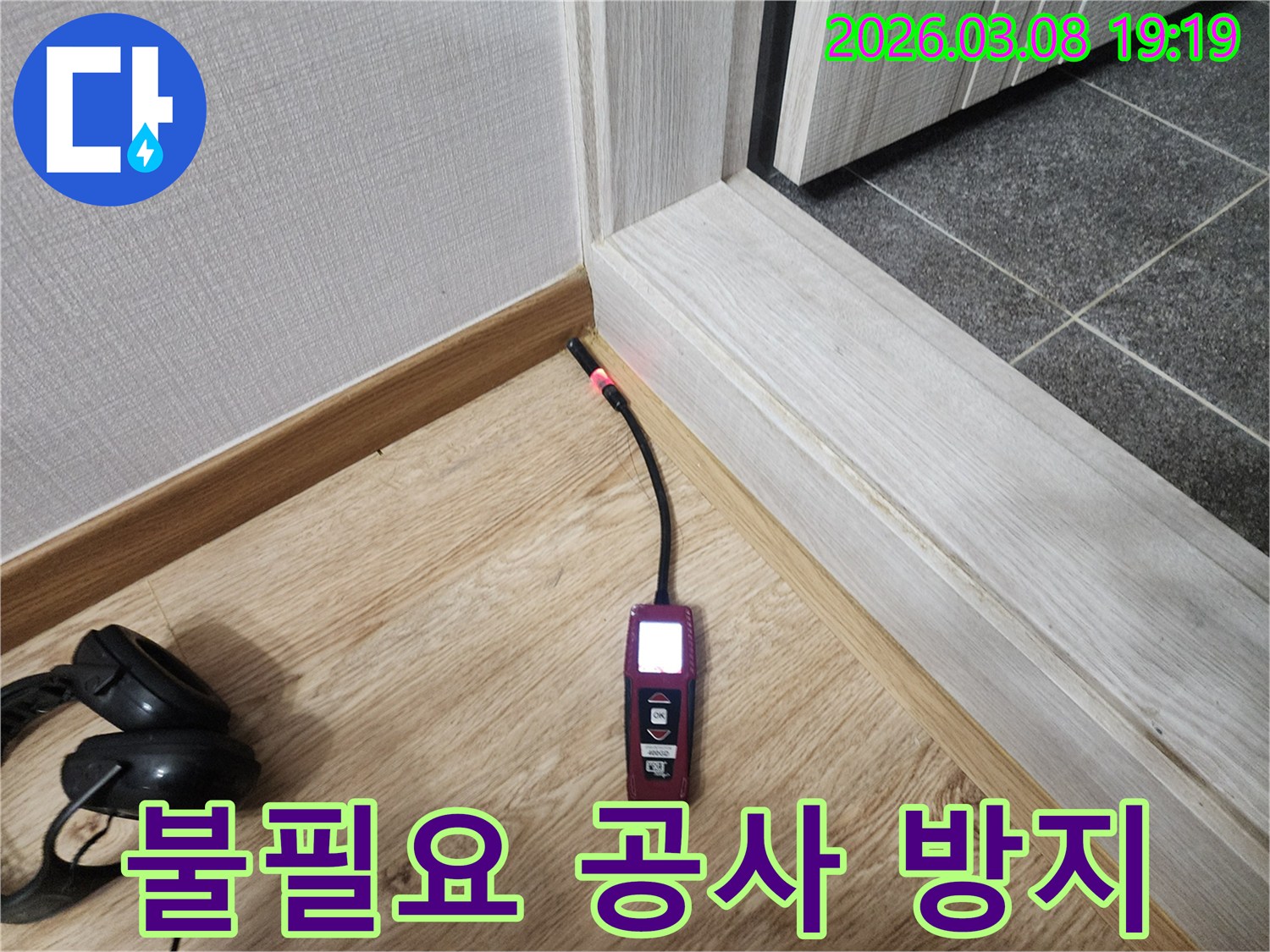 나무-바닥과-벽면-경계에서-누수탐지기가-붉은색-불빛으로-누수-위치를-정확히-지목하여-불필요한-공사를-방지하는-사진