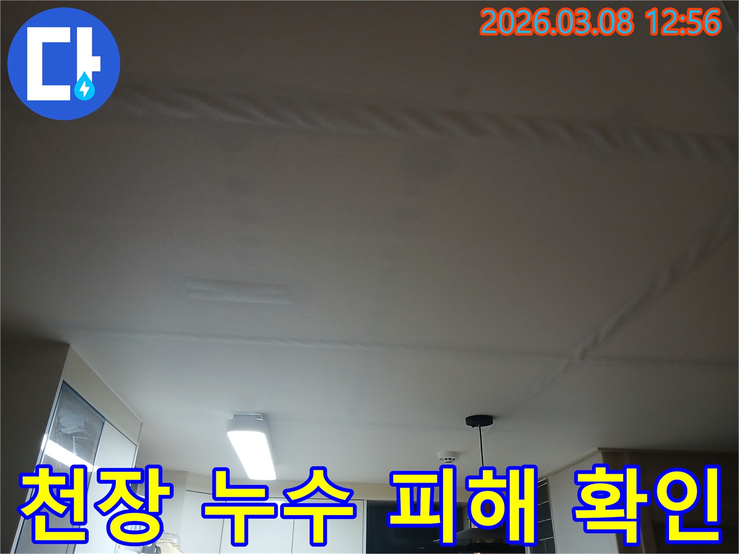 주방 천장에 물이 새어-얼룩지고 마감재가 손상된-누수 현장을 보여주는 사진
