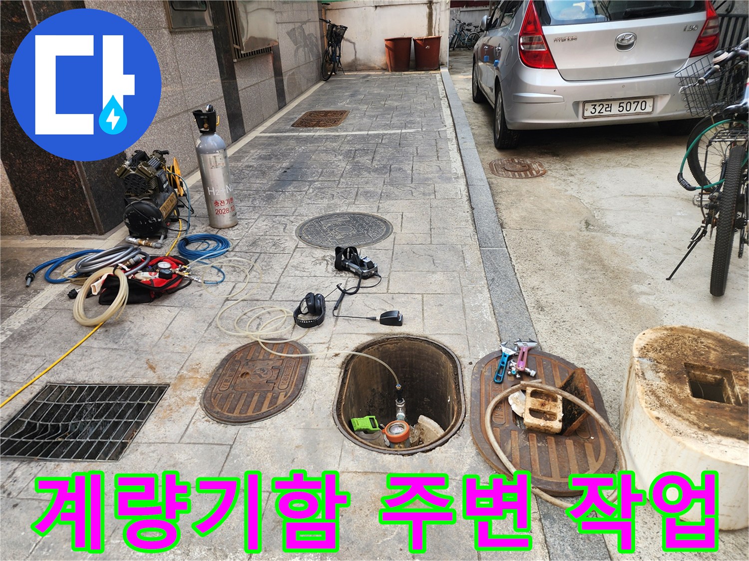 맨홀 덮개가 열려 있는-계량기함 인근의 누수 점검 현장
