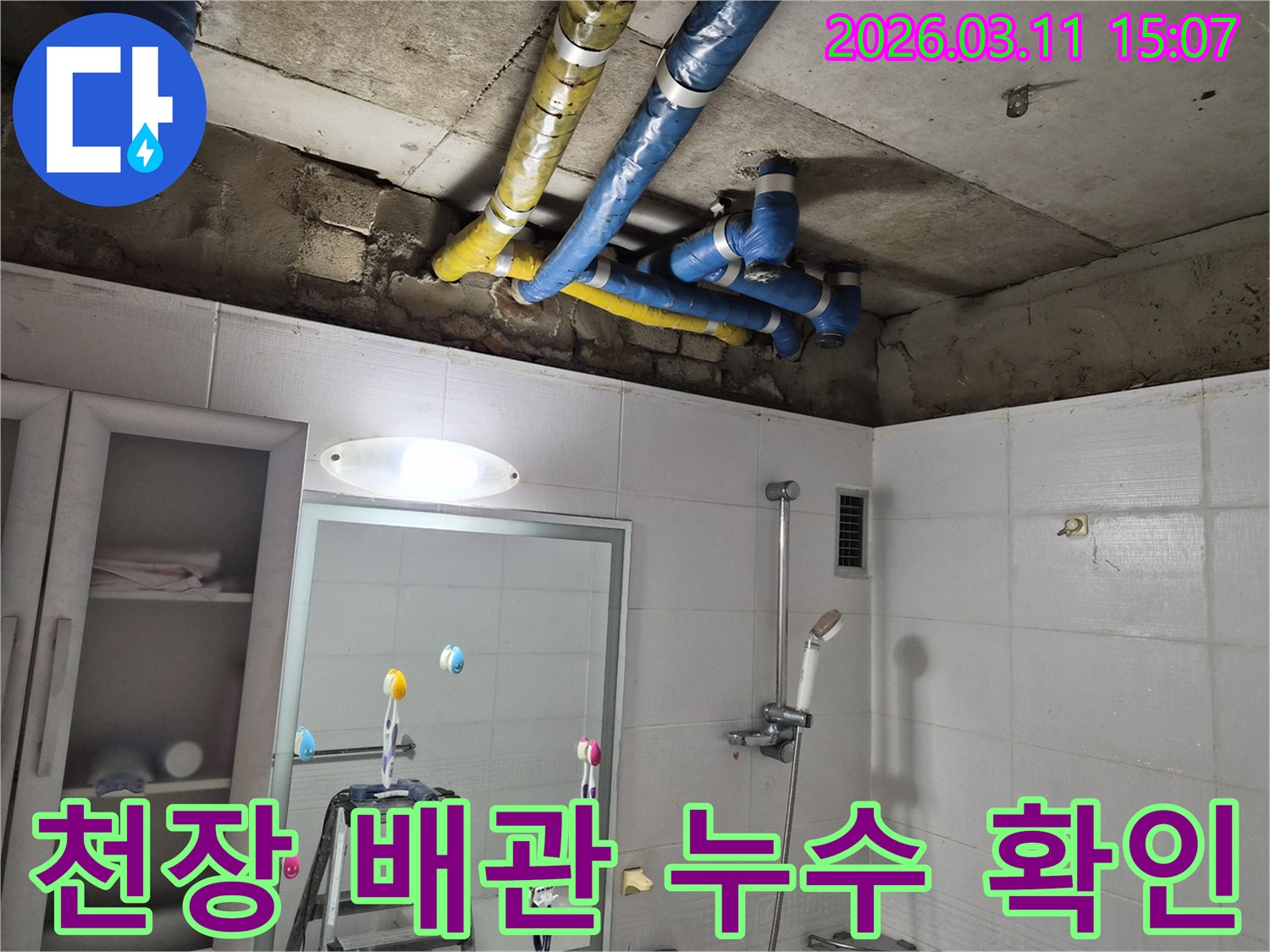 노후된 욕실 천장 배관에서-누수가 발생하여-전문가가 점검하는 모습입니다