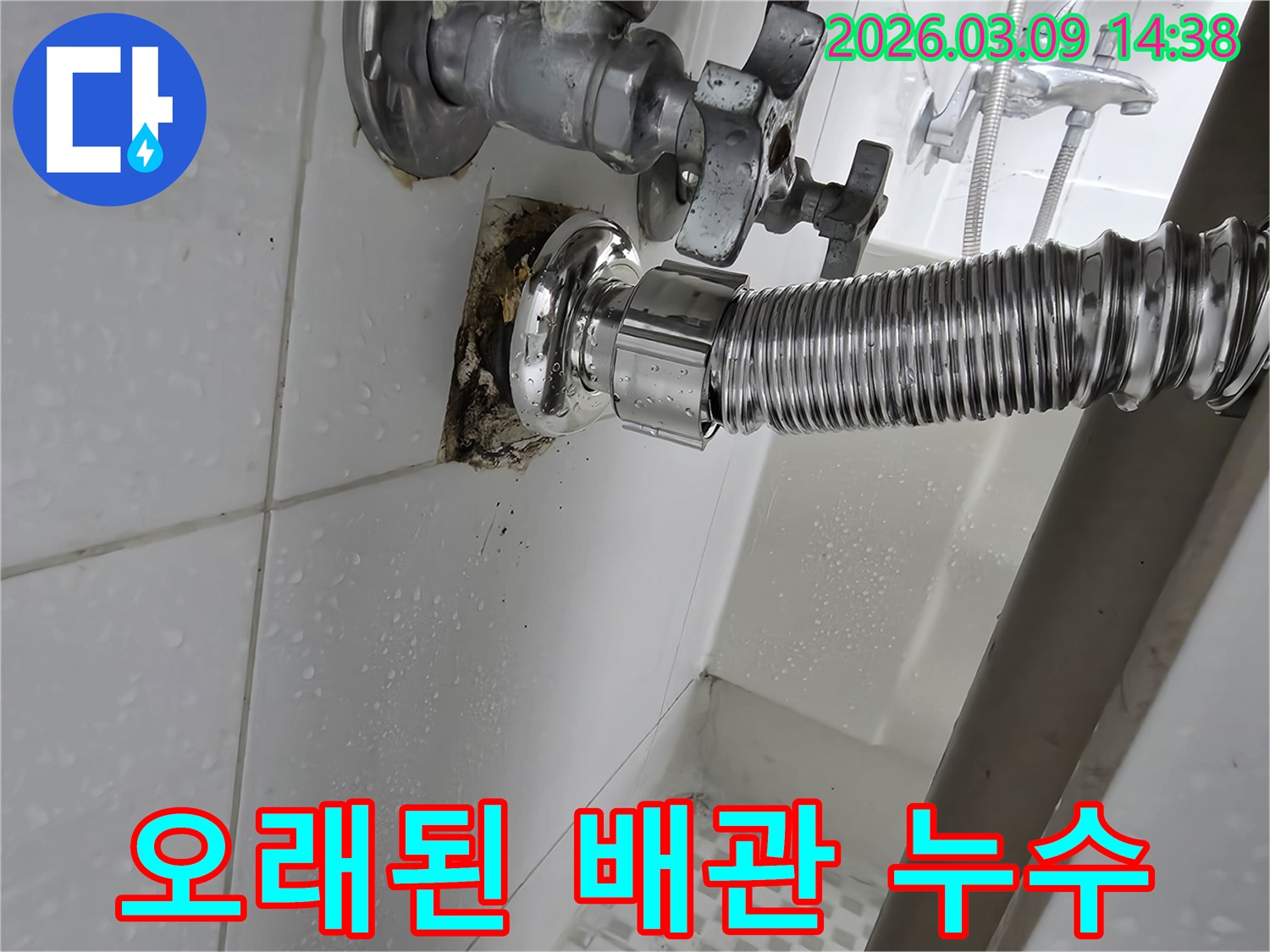 욕실-벽면의-오래된-수도-배관-연결부위에서-누수가-발생하여-타일이-젖고-오염된-모습입니다