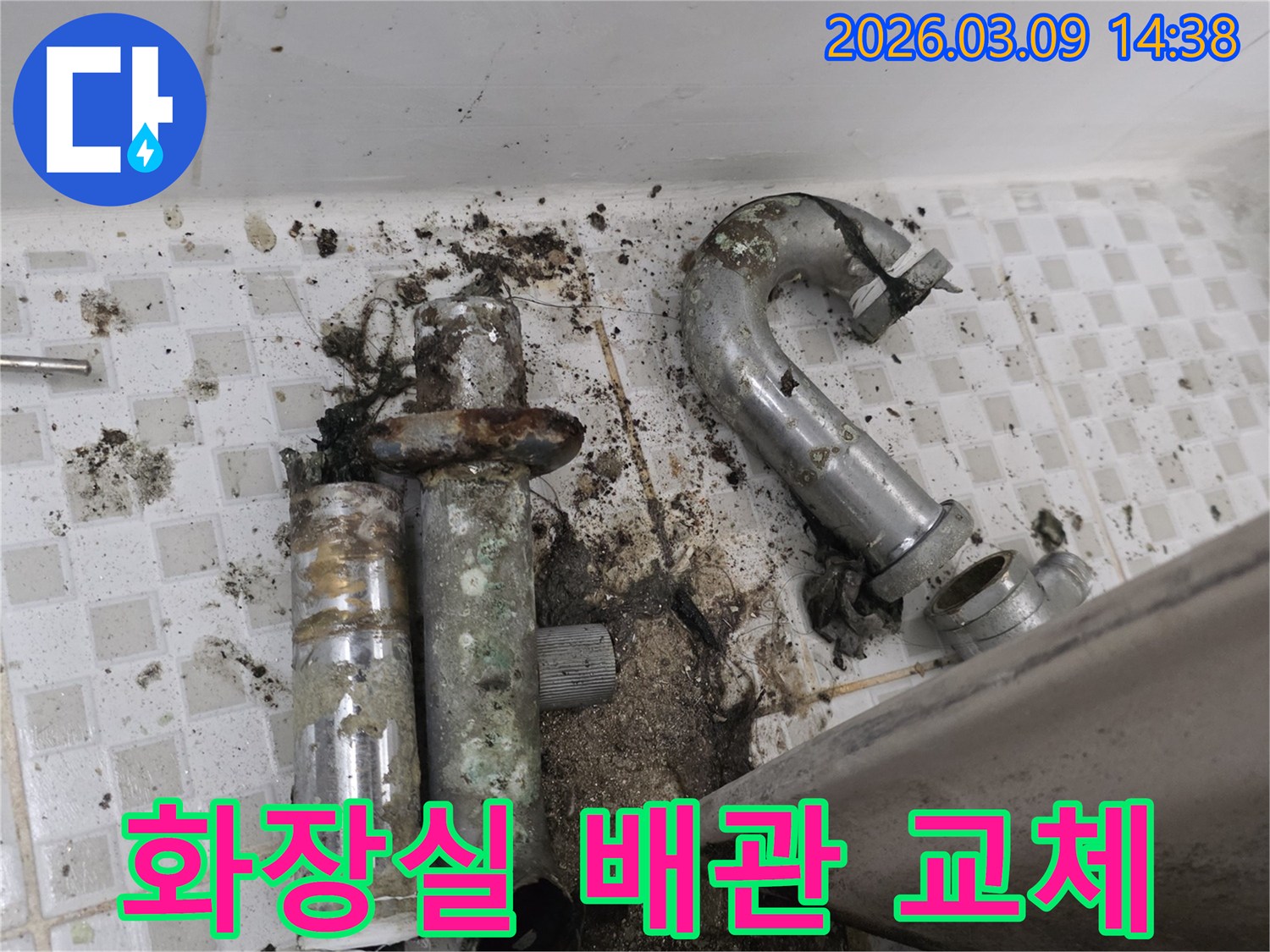 이 이미지는 공릉동 화장실에서 발견된-심하게 부식되어 누수가 발생한 배관과-오염된 바닥을 보여줍니다-교체 전의 모습입니다