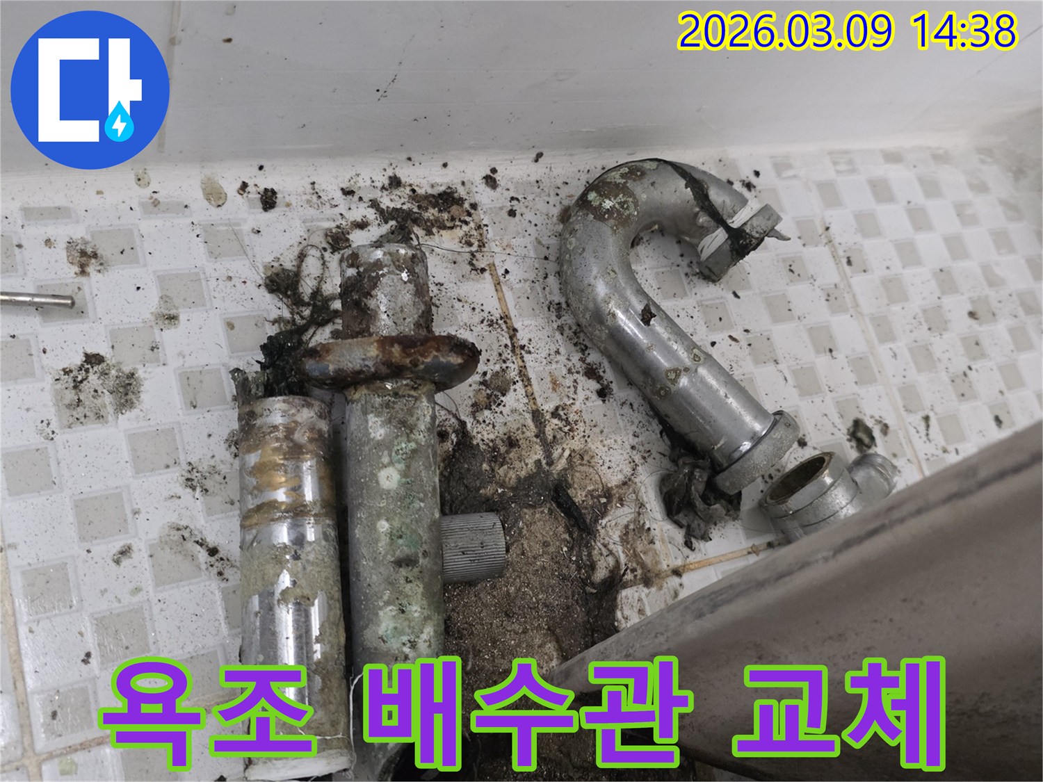 이 이미지는 노원구 공릉동 욕조 아래에서-심하게 부식되어 누수가 발생한 배수관과-오염된 바닥을 보여줍니다-교체 전의 모습입니다