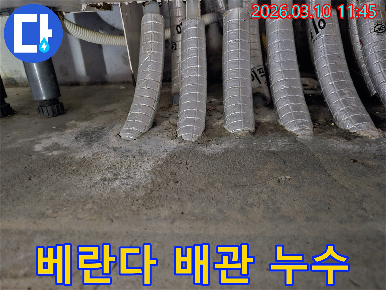 베란다-바닥의-콘크리트에-단열된-배관들이-연결된-지점에서-발견된-물-자국과-백화-현상을-촬영한-사진입니다