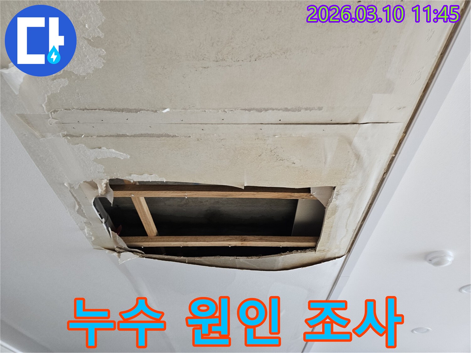천장 누수로 인해-벽지가 들뜨고-내부가 노출된-심각한 물 피해 상황을-보여주는 사진입니다.
