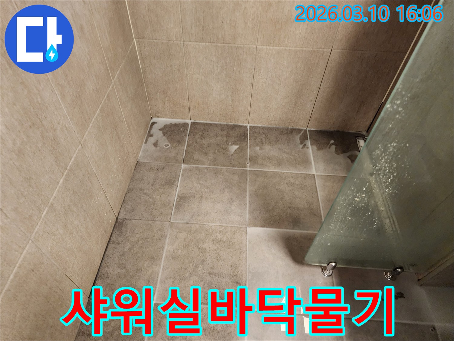 샤워 공간 바닥에 물기가 고여 있고-주변으로 확산되는-누수 현장 이미지입니다.