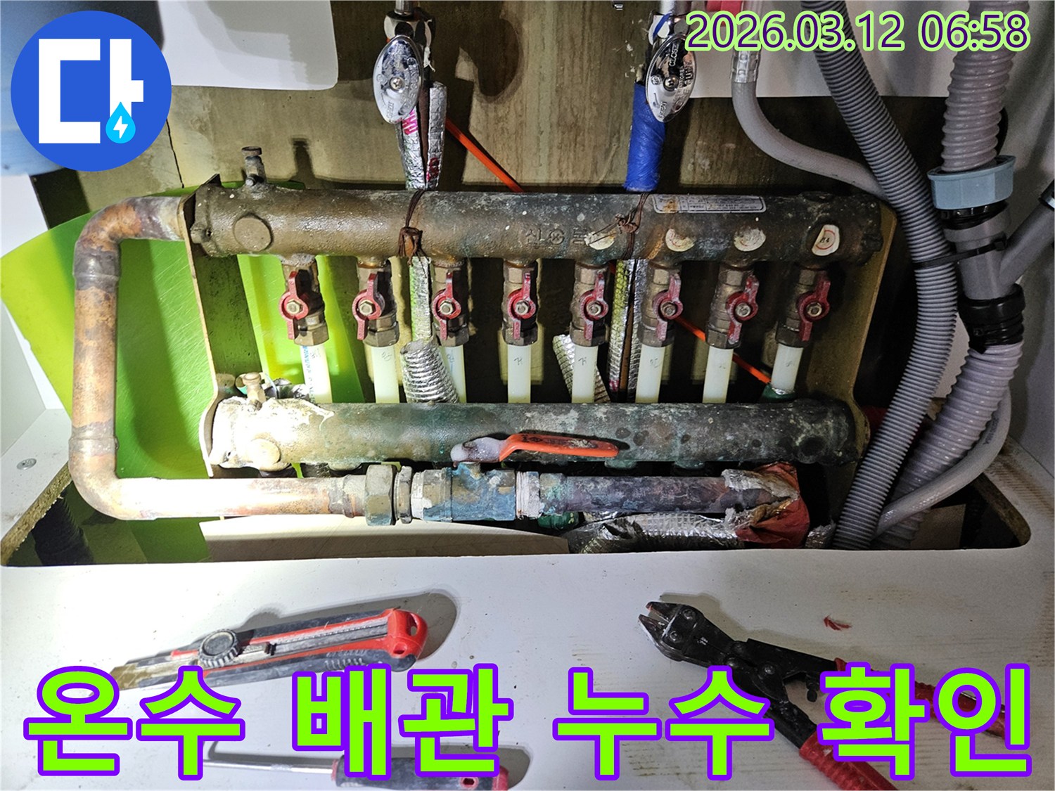 노후된 온수 배관에서 발생한 누수를-전문가가 방문하여-정밀하게 점검하는-과정을 담은 사진입니다