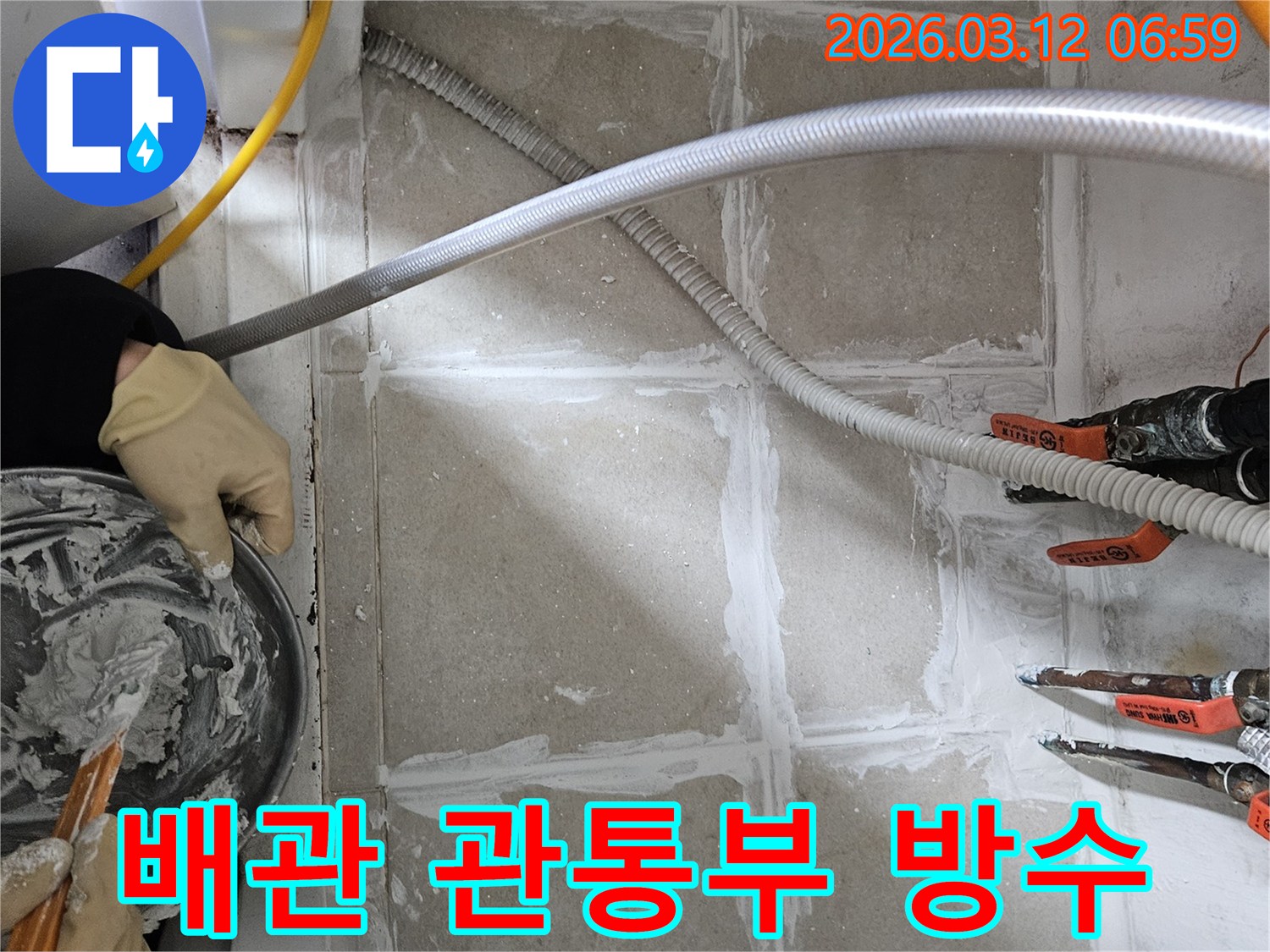 누수 엔지니어가 상가 배관 관통부 바닥에 누수 방지를 위한 방수 실링 작업을 세밀하게 적용하고 있습니다