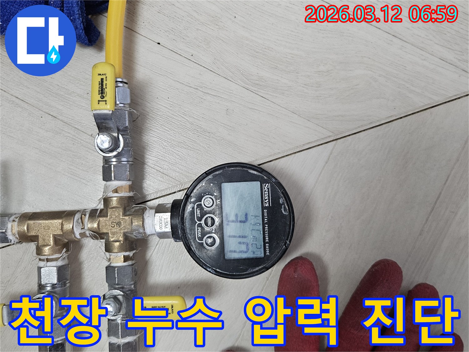 누수-전문가가-디지털-압력계를-사용해-배관의-미세한-압력-변화를-감지하여-천장-누수-원인을-꼼꼼히-진단하는-모습