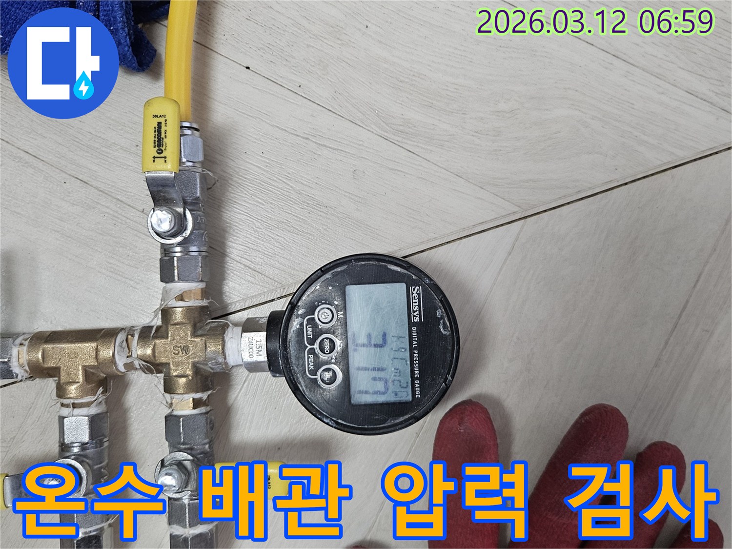 배관-누수-원인을-파악하기-위해-정밀-압력-측정-장비를-사용하여-온수-배관을-검사하는-모습