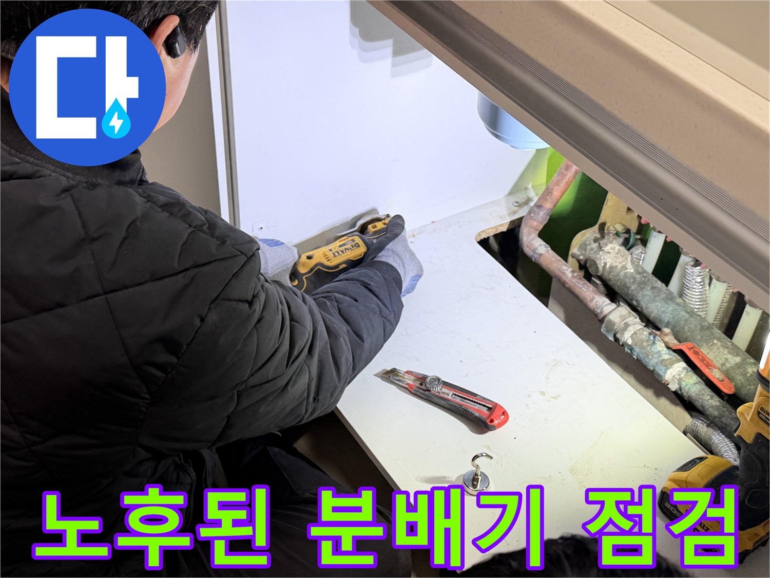 싱크대 하부장 내부-부식된 배관과 작업 도구