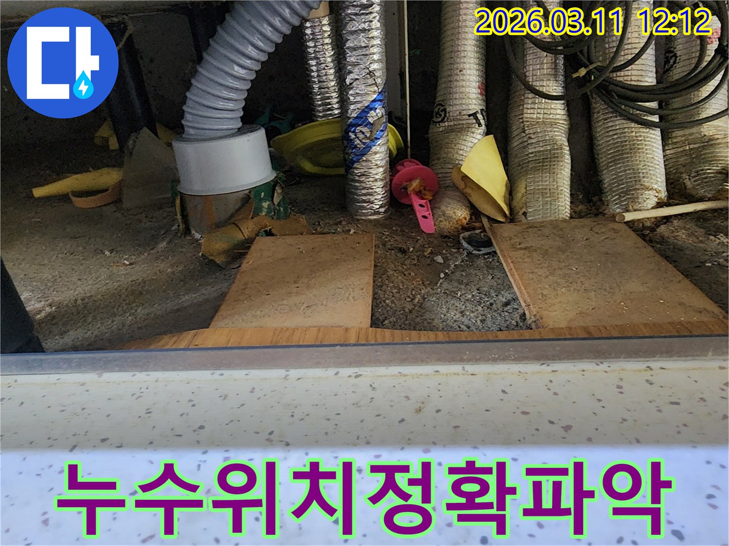누수-전문가가-복잡한-배관-아래-누수-위치를-정확히-파악하기-위해-집중하는-모습을-담은-사진입니다