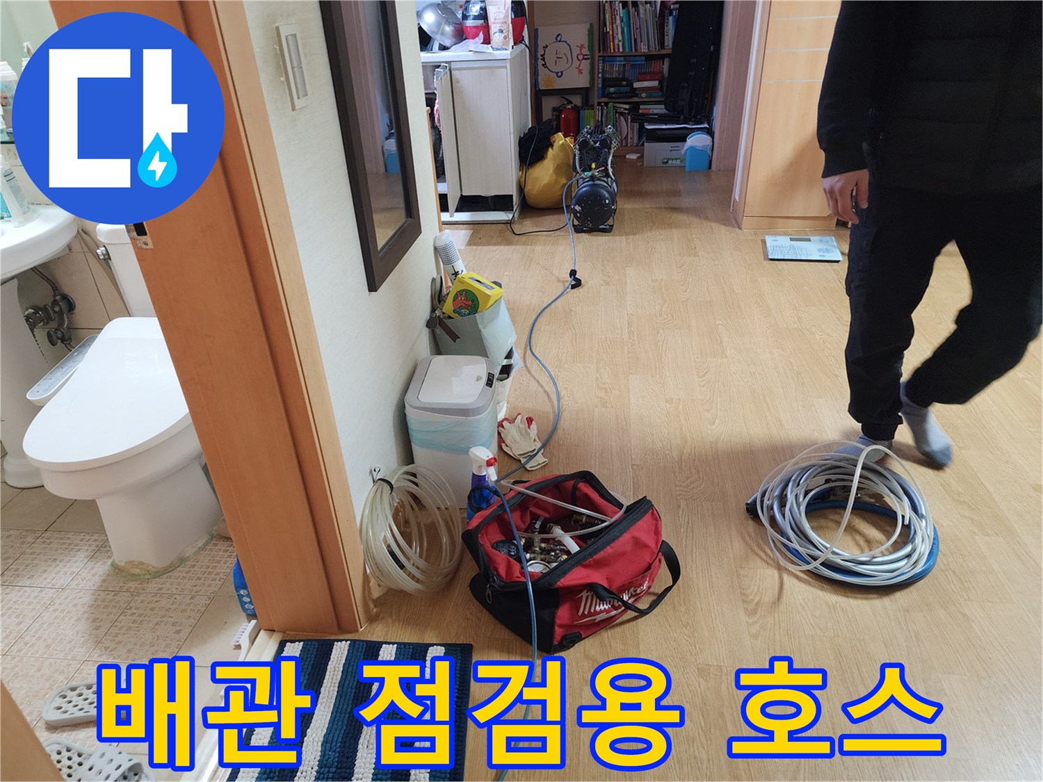 바닥에 넓게 펼쳐진 파란색과 흰색의 배관 압력 테스트용 호스 뭉치