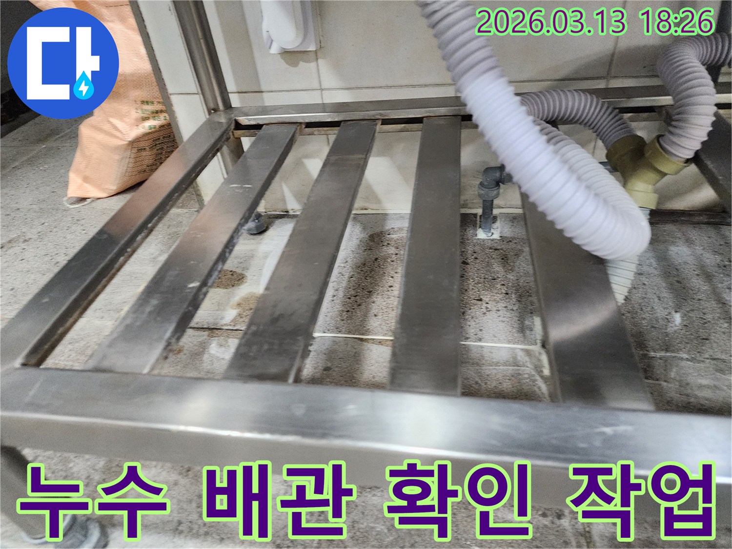 누수-현장에서-배수 호스와-연결된 배관의-손상 여부를-면밀히 검토하는-엔지니어의 모습