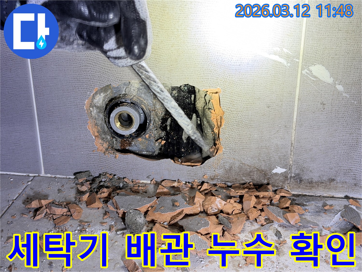 장갑 낀 손이-벽 속 세탁기 배관의 누수 지점을-정밀하게 진단하기 위해-해체하는 모습입니다