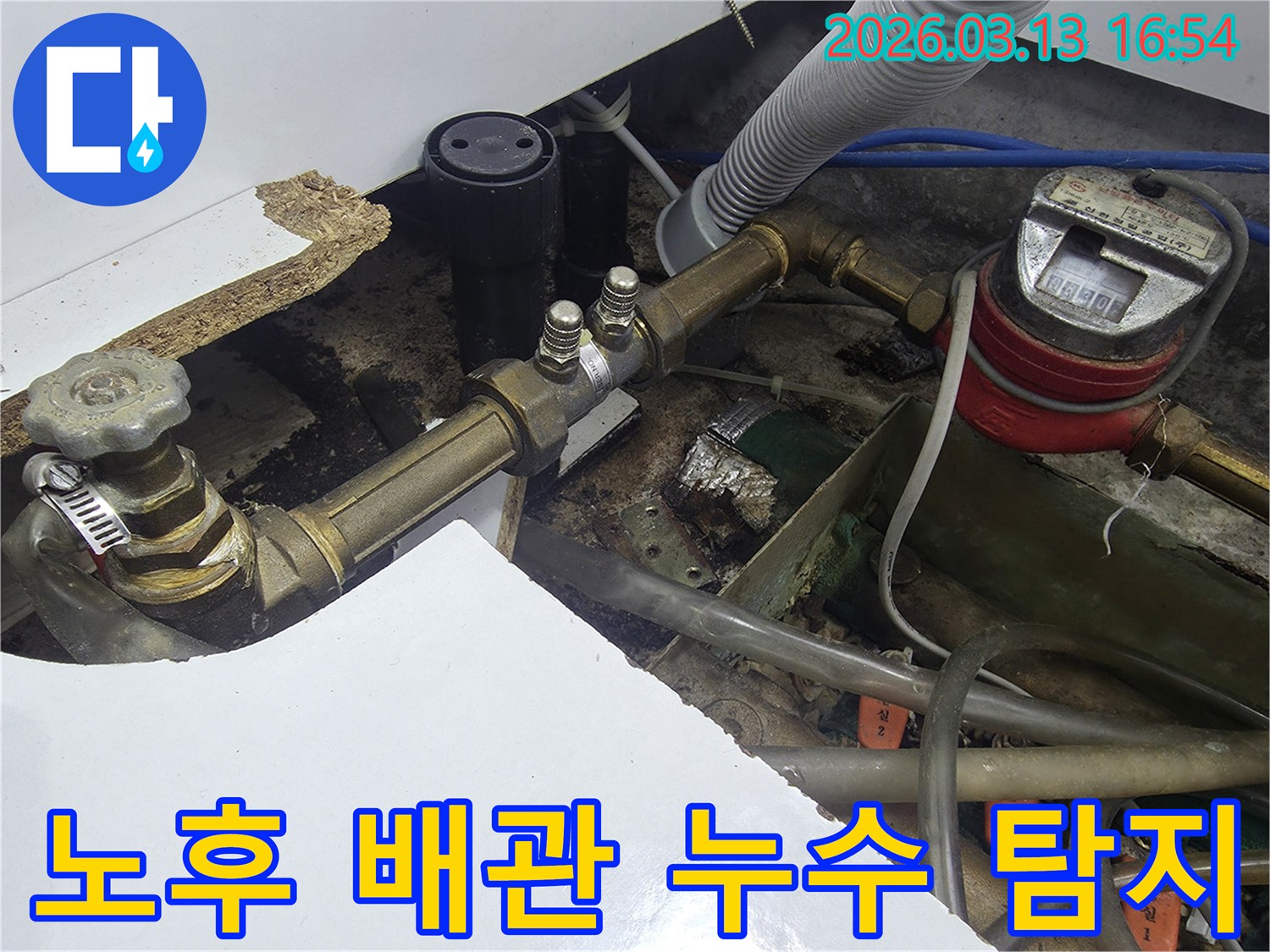 바닥 아래 노출된 노후 배관에서-누수 지점을 찾아내기 위해-전문가가 면밀히 탐지하는 현장