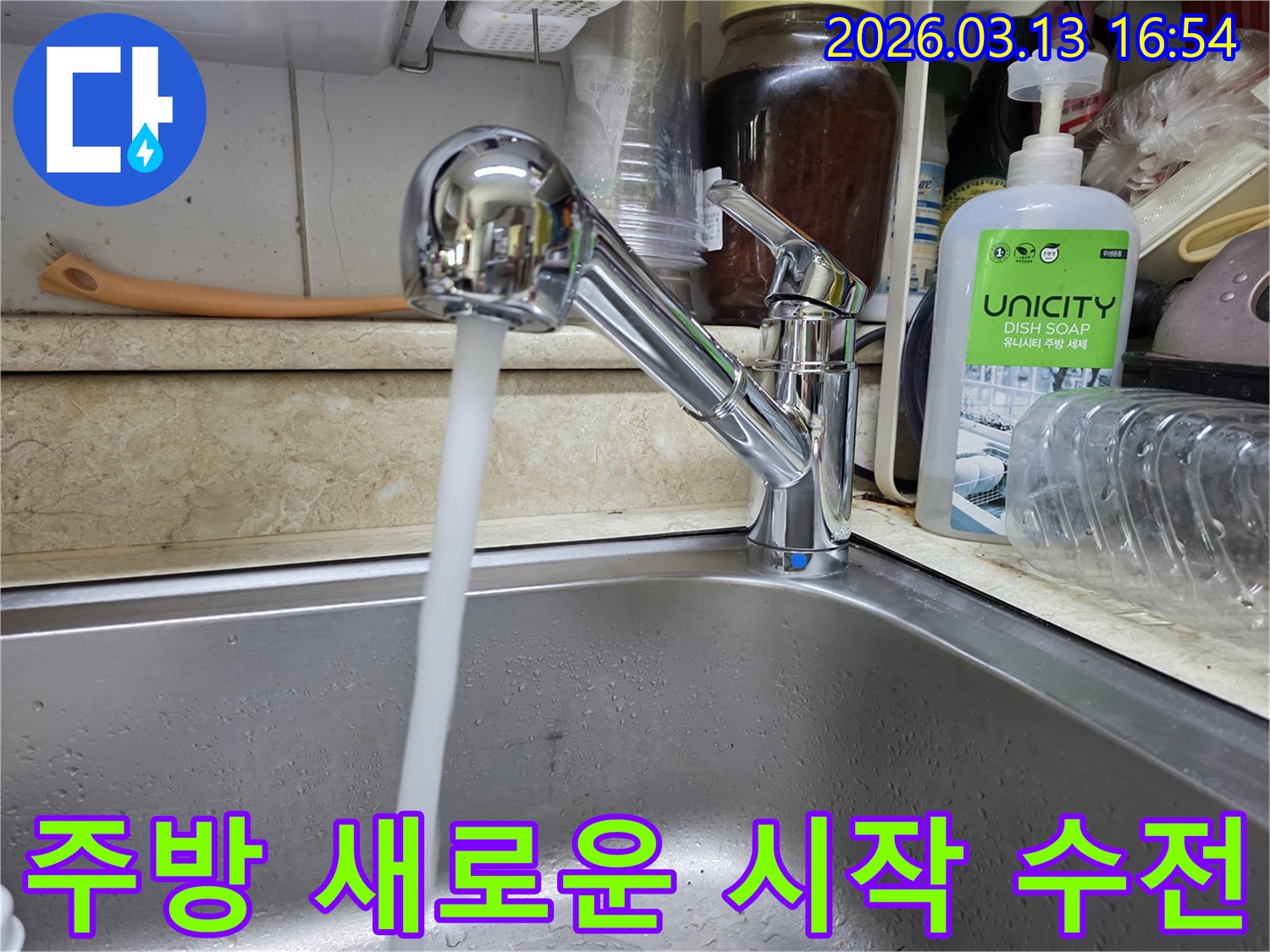 새롭게 교체된 싱크대 수전에서 물이 깨끗하게 흘러나오는 모습-주방의 새로운 시작을 알리며 쾌적하고 편리한 환경을 제공합니다