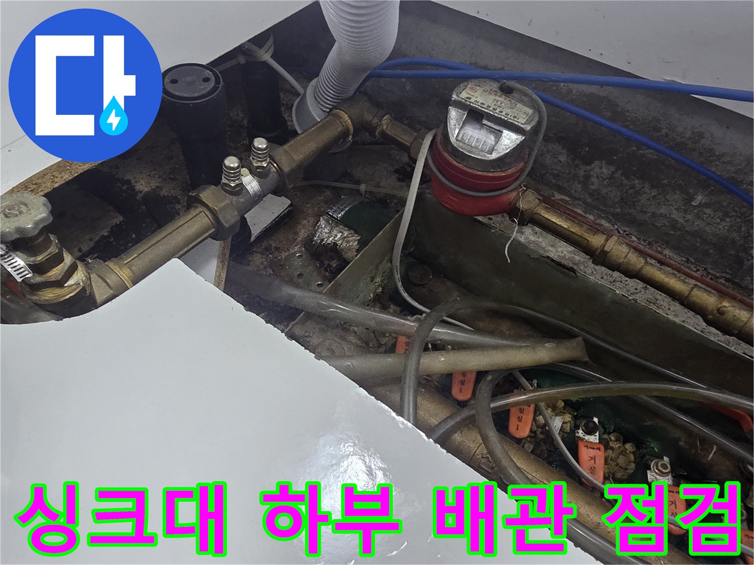 오산 운암동-싱크대 하부의 수도 계량기와 복잡한 배관 연결 상태를 확인하는 모습