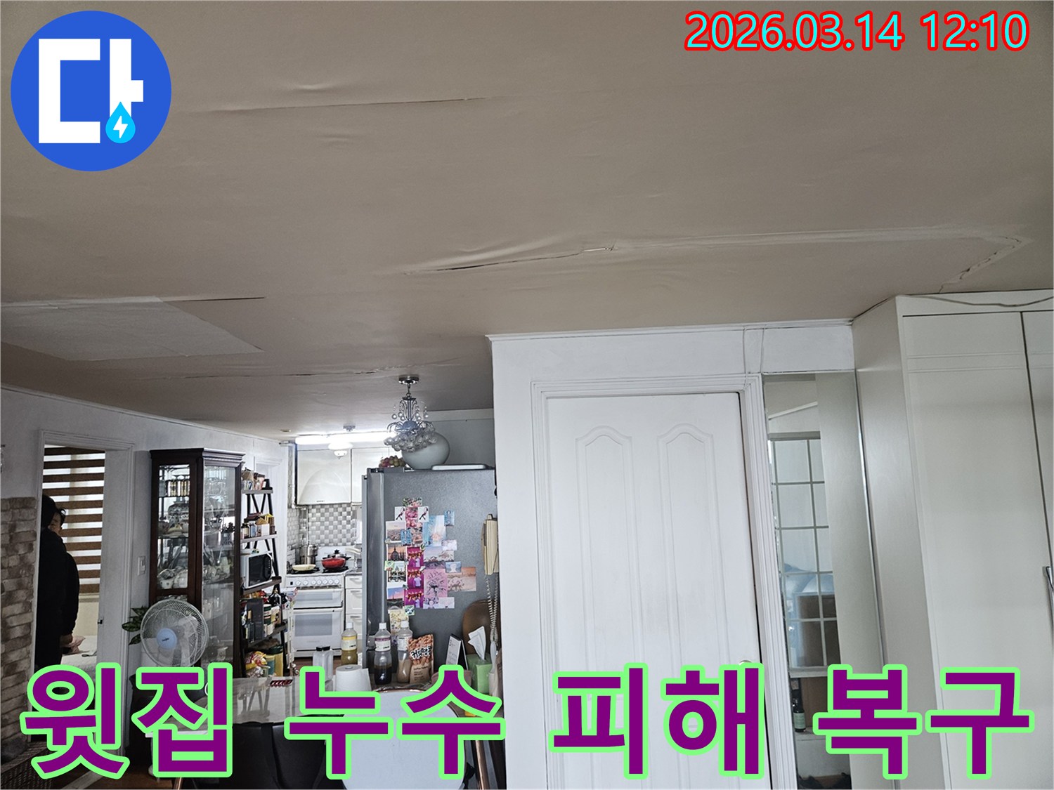 이 이미지는 윗집 누수로 인해-아파트 천장이-심하게 손상된 모습을-보여줍니다-천장 마감재가 물에 젖어-변색되고-일부가 처진 현상은-신속한 누수 원인 진단과-복구 작업이-필요함을-나타냅니다