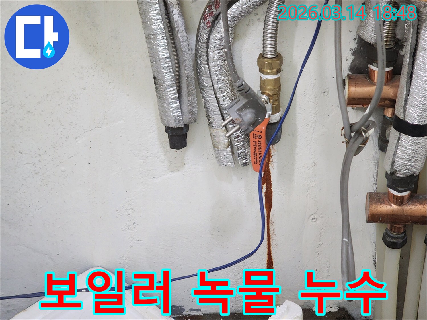 보일러-배관의-연결부에서-녹물이-새어-나와-벽면을-오염시키는-누수-현장-사진
