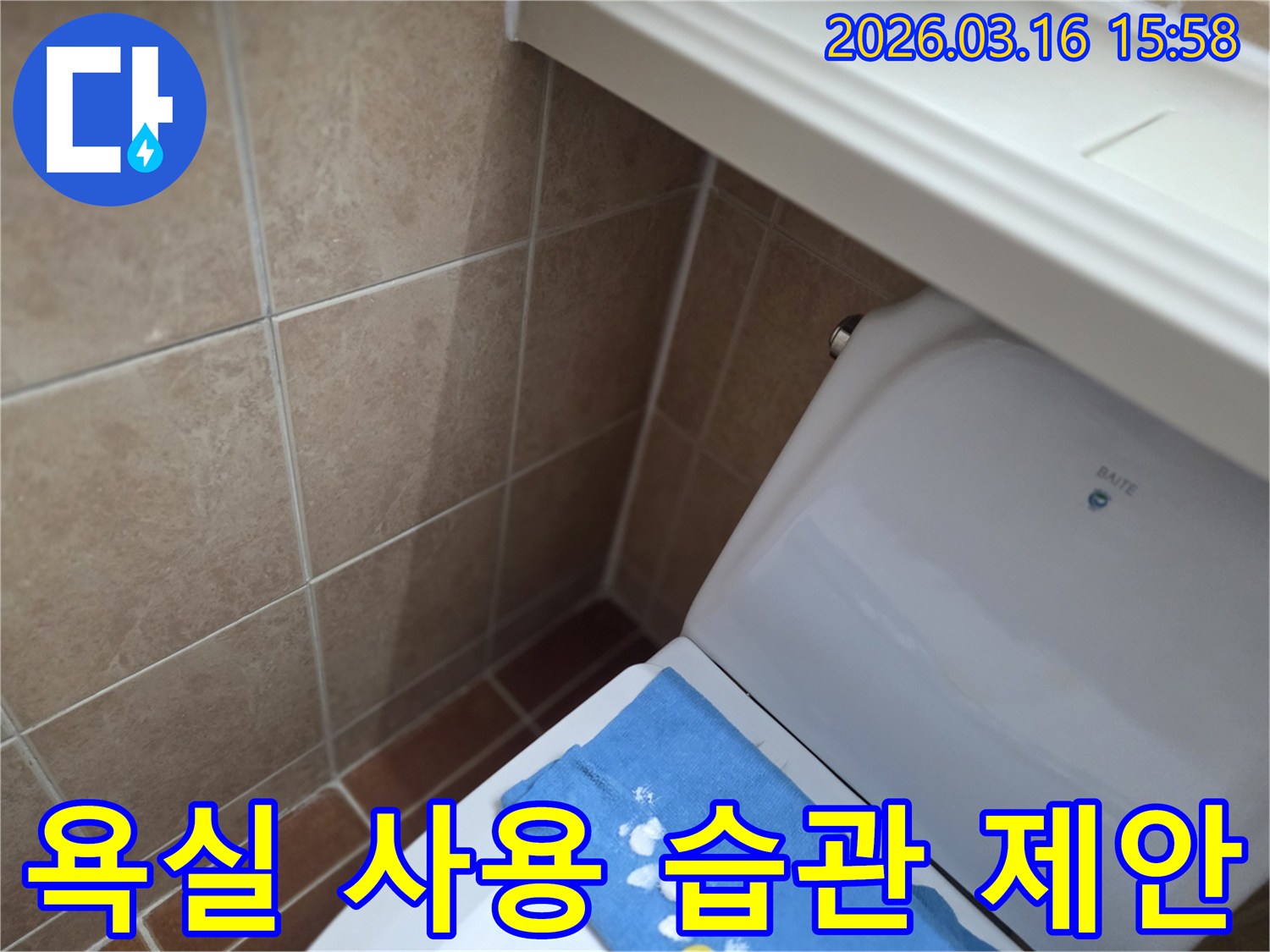 오산시 운암동의-한 욕실에서-변기 뒤편-벽면 타일의 젖음으로-누수 수리 후-누수 방지를 위한-욕실 사용 습관 개선을-제안하는 현장을-보여주는 사진입니다.