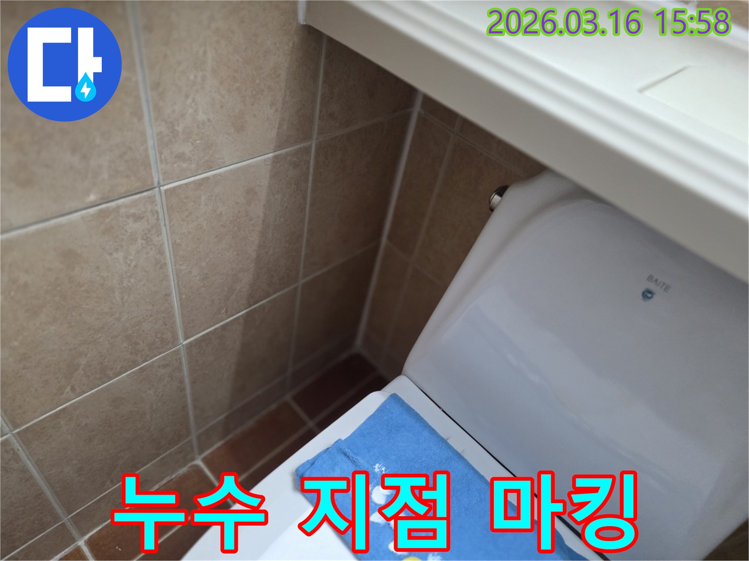 오산시 운암동의-한 욕실에서-변기 뒤편-벽면 타일의 젖음으로-누수 지점을-정확히 마킹하고-보수 작업을-준비하는 현장을-보여주는 사진입니다.