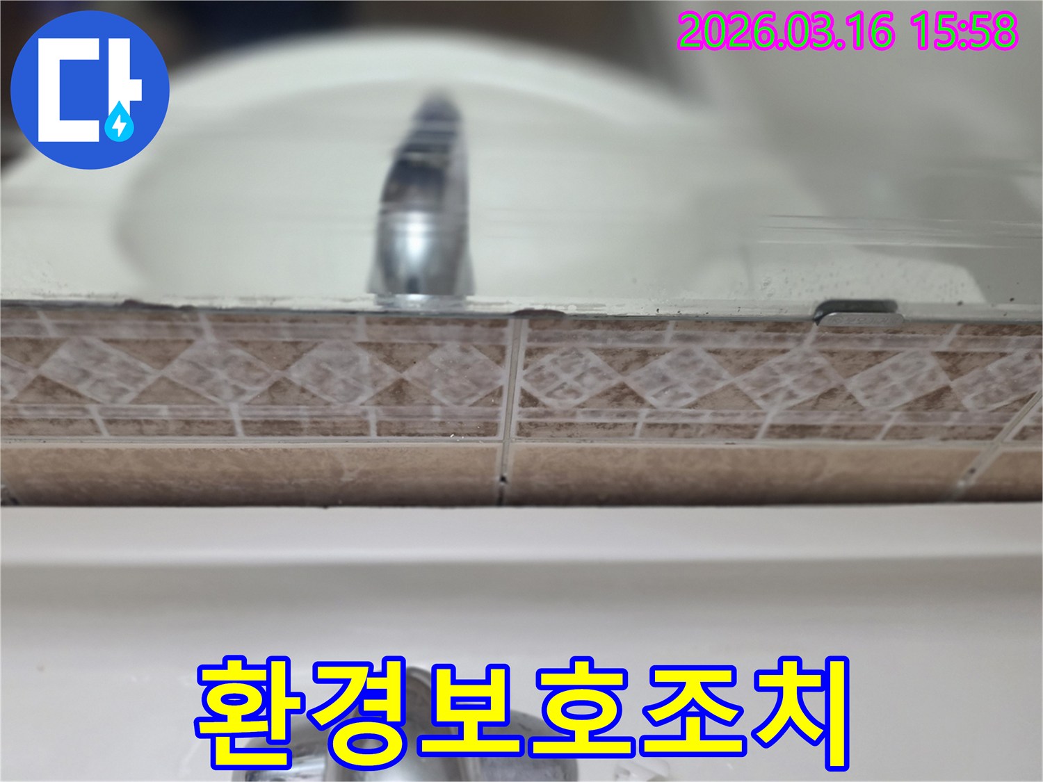욕실-세면대-뒤-타일-틈새의-누수-흔적을-촬영하여-환경-보호를-위한-누수-조치의-중요성을-설명하는-사진