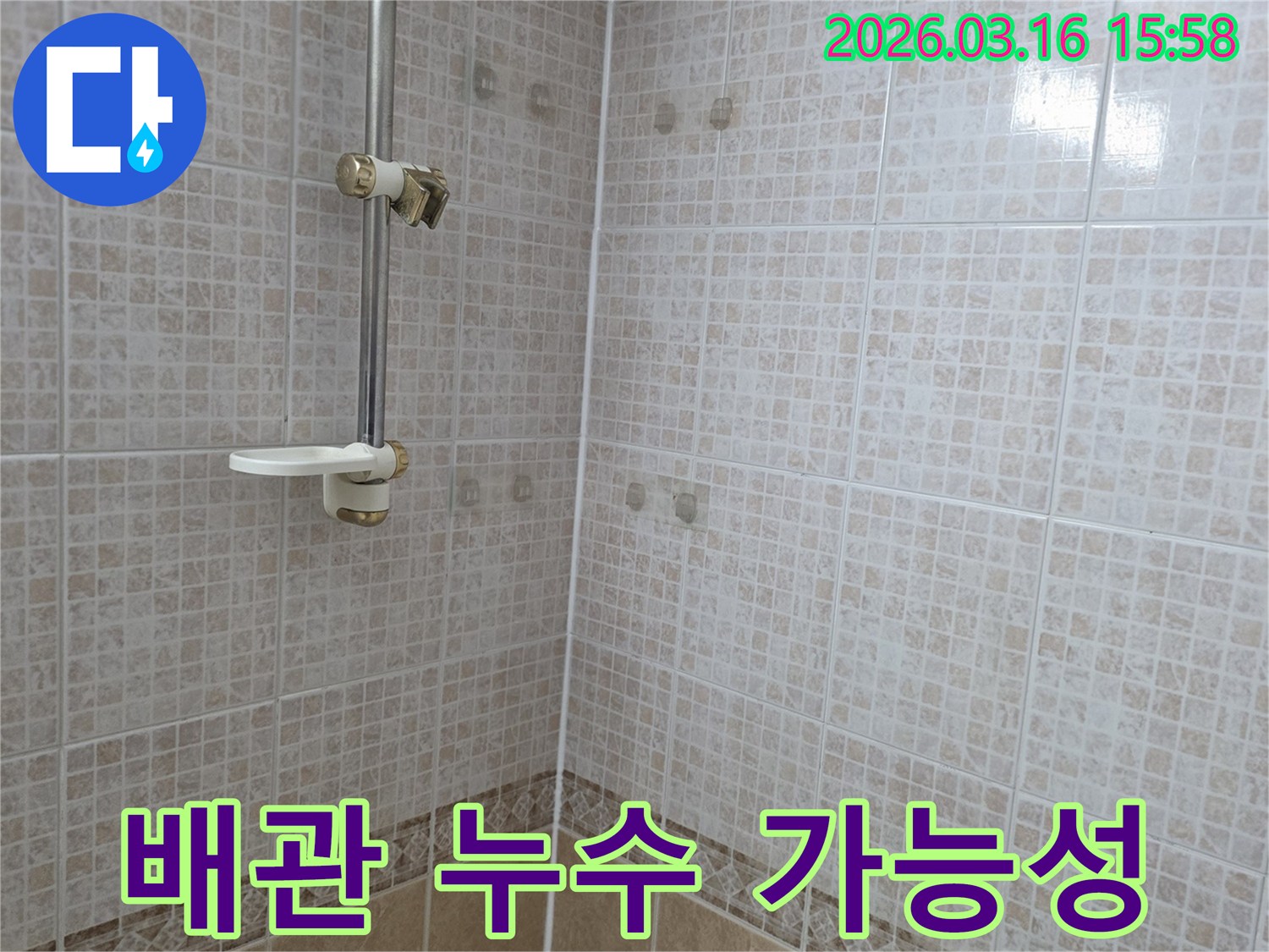 욕실 천장 타일에 물이 새어 생긴 얼룩으로-천장 내부 배관 누수 가능성을 누수 전문가가 탐지하는 모습