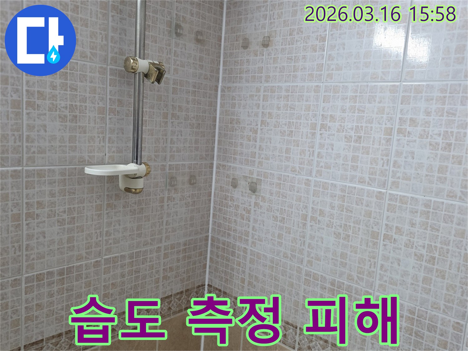 욕실 천장 타일에 물이 새어 생긴 얼룩을-습도 측정기로 피해 정도를 파악하는 누수 전문가의 모습