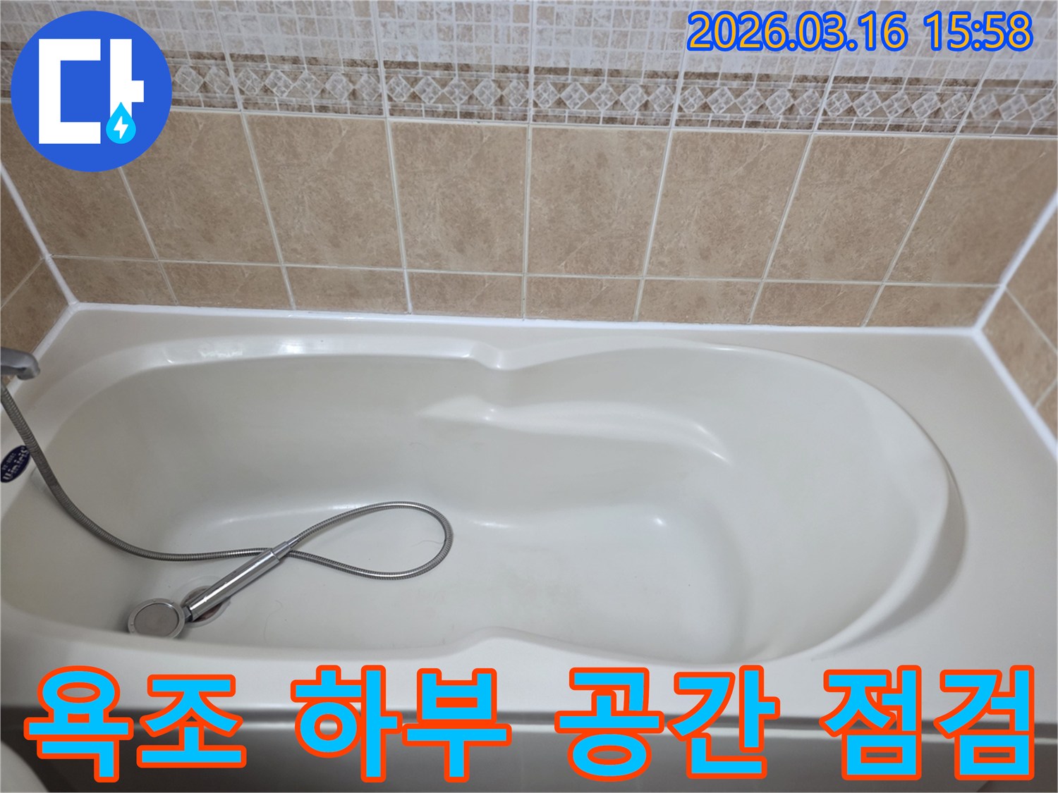 욕실의-흰색-욕조와-타일-그리고-샤워기가-보이는-욕조-하부-공간의-누수를-정밀-점검하는-현장-사진입니다