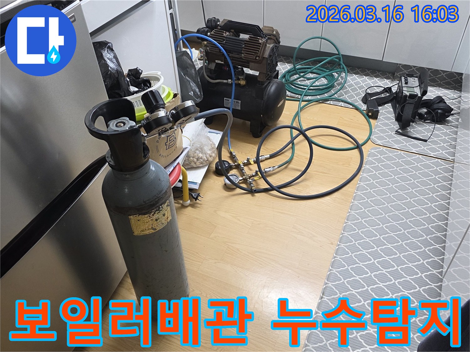 보일러 배관 누수 여부를 확인하기 위해-질소 가스통과 압축기를 연결하여-압력 테스트를 준비하는 현장입니다