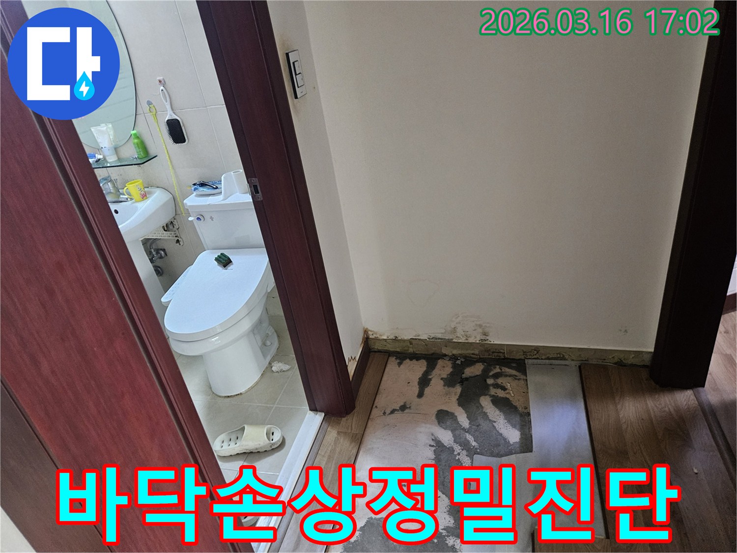 누수 탐지 후-욕실 앞 바닥재를-제거하고-곰팡이와-물자국이 드러난-상태를 보여주는-사진
