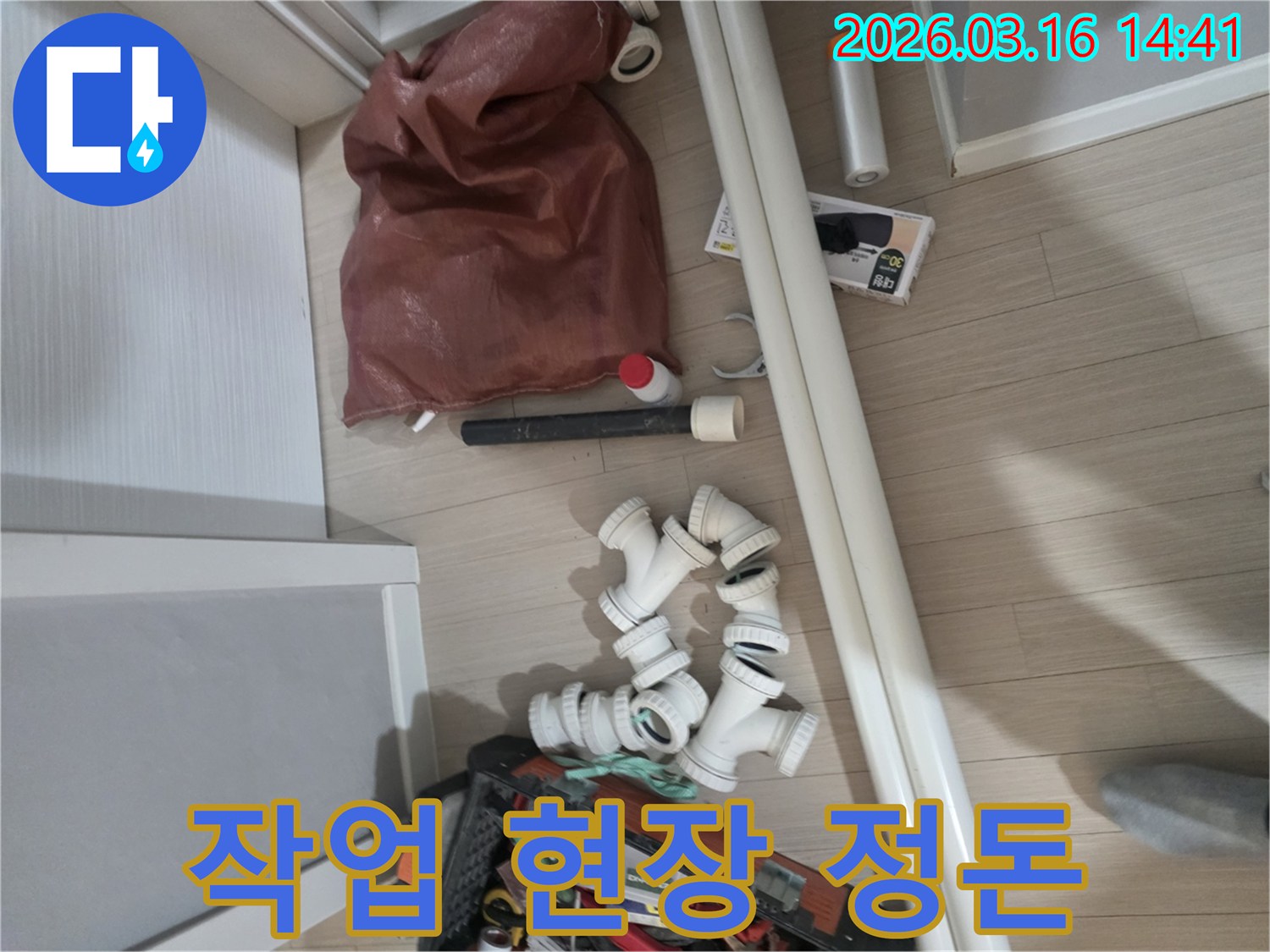 누수-수리-작업에-필요한-다양한-배관-자재와-전문-공구들이-바닥에-가지런히-정돈되어-있습니다