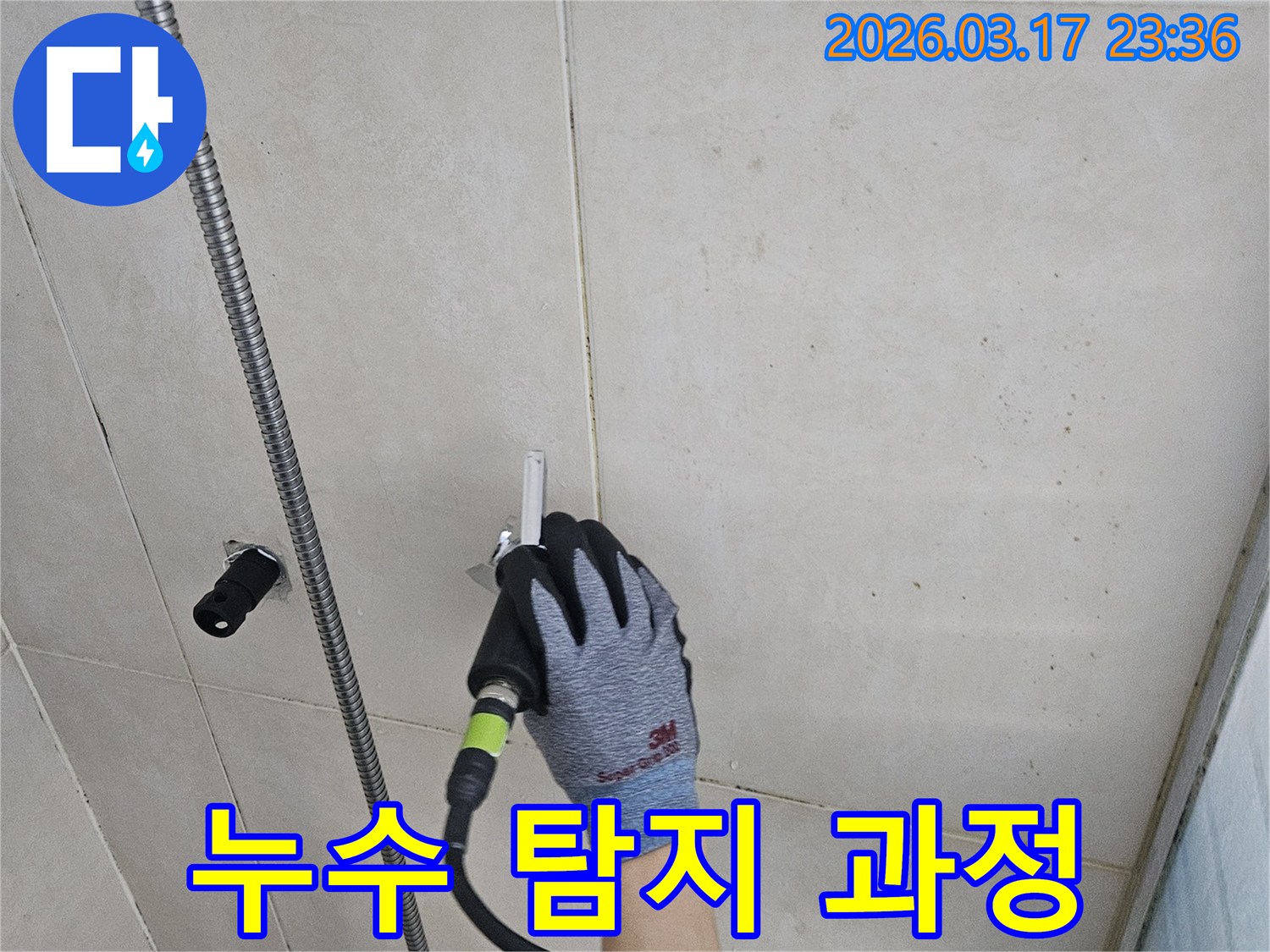 누수 전문 엔지니어가-첨단 장비로-타일 벽면의 누수 여부를 면밀히 확인하는 모습입니다