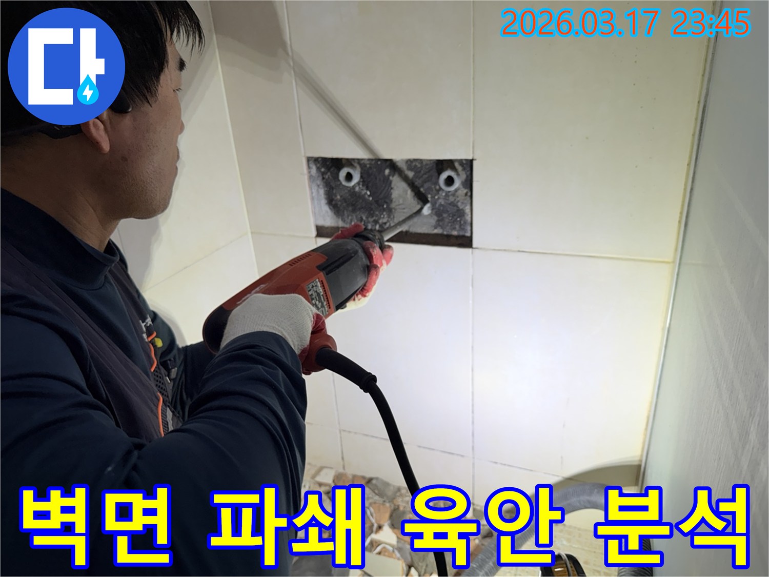 누수 전문가가 벽면 타일을 깨끗하게 파쇄하며-누수 원인인 배관의 문제점을 육안으로 확인하고 분석하는 작업을 진행 중입니다.