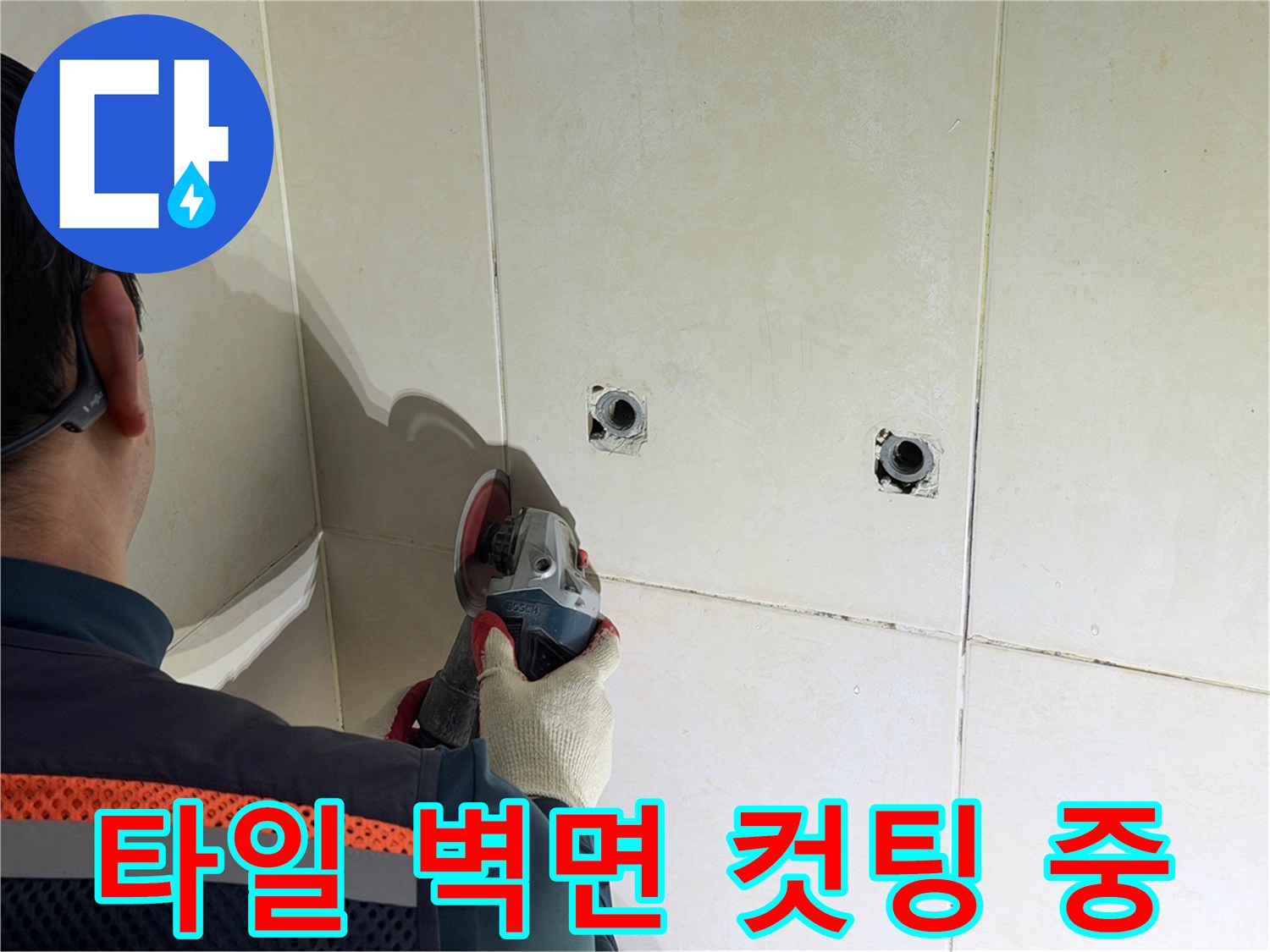 누수 지점을 찾아 타일 면을 사각형으로 절개하는 작업 장면입니다.