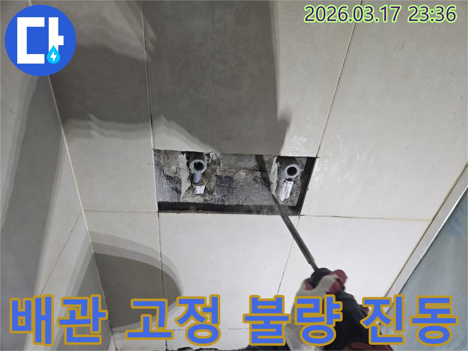 누수 해결을 위한-필수 단계로-벽면 타일 파쇄 후-배관을 노출하여-배관 고정 불량으로 인한-진동 누수를-확인하는 모습입니다