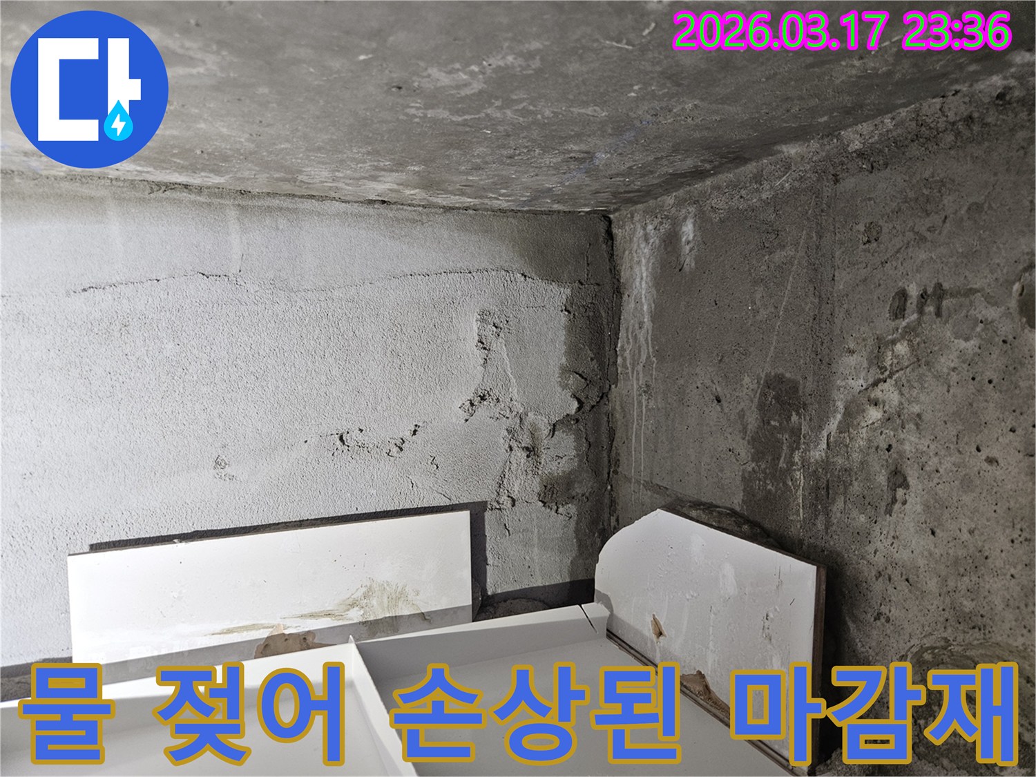 누수로 인해 바닥에 놓인 마감재가 물에 젖어 손상된 모습-내부 누수가 진행되고 있음을 보여줍니다.