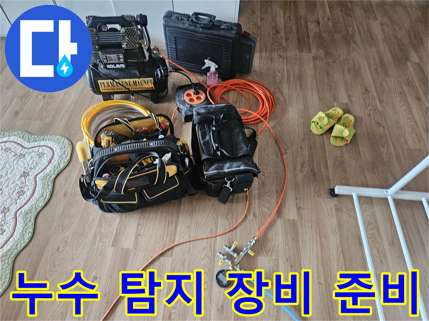 배관 누수 확인을 위해 거실에 배치된-탐지 도구와 호스 릴