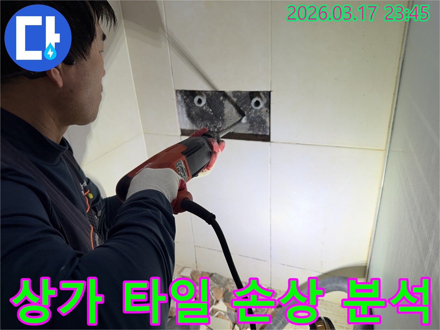 숙련된 기술자가 상가 누수 지점을 찾아내기 위해-벽면 타일을 깨고 내부 배관의 손상 여부를 정밀 분석하는 작업을 진행하고 있습니다.