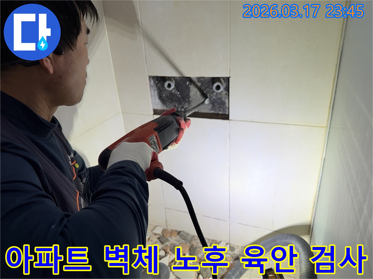 숙련된 기술자가 아파트 욕실 벽체를 파쇄하여-내부 배관의 노후화 여부를 육안으로 검사하는 작업 현장입니다.