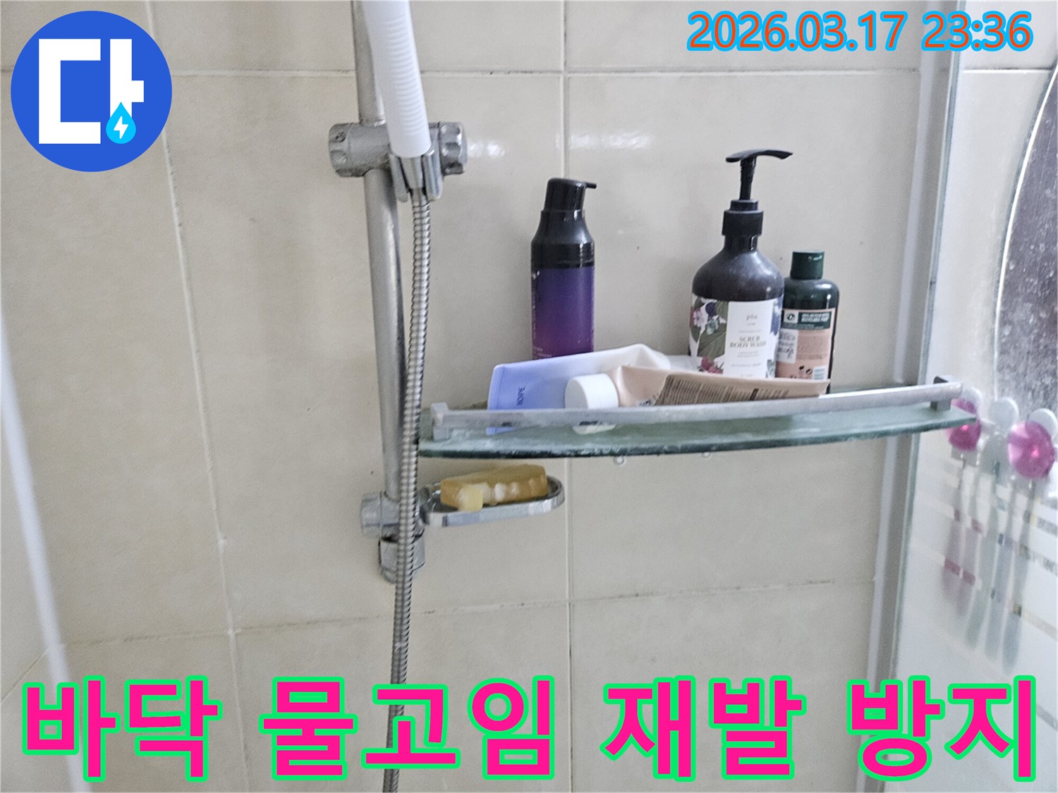 욕실 샤워기 옆-유리 선반에 맺힌 물방울은-바닥 물고임의 간접적인 증거를 보여주는 이미지입니다